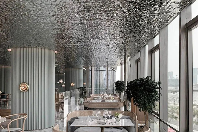 Silver water ripple stainless steel ceiling installed with recessed downlights and wood trim